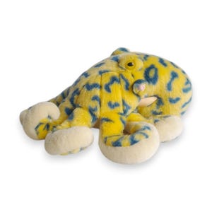 May include: A plush octopus toy in yellow with blue spots. The toy has eight cream-colored tentacles and a small pink mouth. The octopus has a friendly expression and is made of soft material.