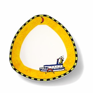 May include: A decorative, triangular plate with a white interior and a yellow border. The border has a black and green checkered pattern. A cartoon steamboat with a red paddle wheel and blue accents is featured on the plate.