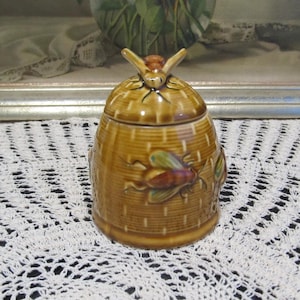 Vintage honingpot versierd met bijen en een deksel met gat voor een honinglepel, gemaakt in Duitsland
