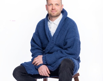 May include: A chunky knit navy blue cardigan with a wide shawl collar, worn over a white collared shirt and black pants. The cardigan features a thick, textured yarn construction with long sleeves and a relaxed, open-front design.