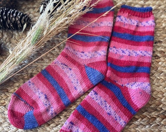 May include: A pair of hand-knitted socks in a pink and blue striped pattern. The socks are made with a soft, fuzzy yarn and have a comfortable fit.