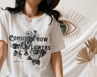 May include: White t-shirt with a black graphic print of flowers and the text "Consider How The Wildflowers Grow" and "Luke 12:27".