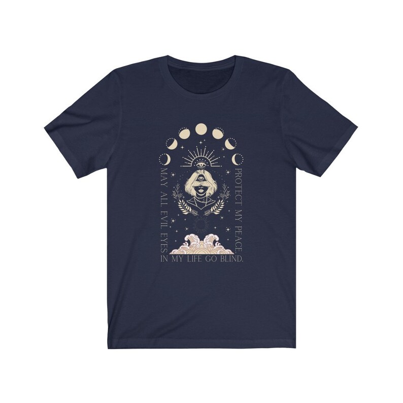May include: Navy blue t-shirt featuring a graphic with a woman's face, an eye, and moon phases. The text reads "MAY ALL EVIL EYES IN MY LIFE GO BLIND. PROTECT MY PEACE."