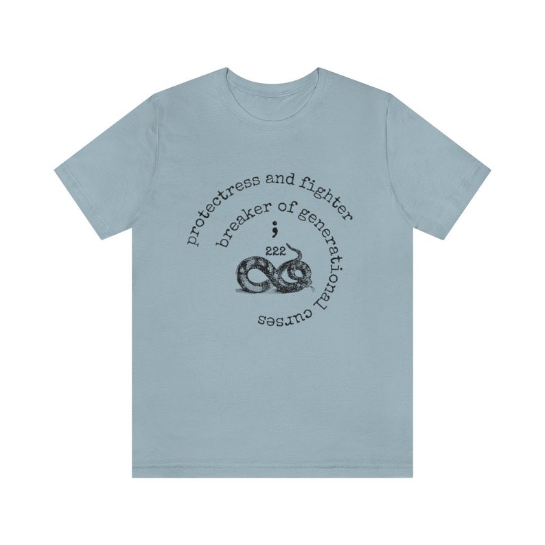 May include: Light blue t-shirt with a circular design featuring a snake, the text "protectress and fighter breaker of generational curses", and the number "222".