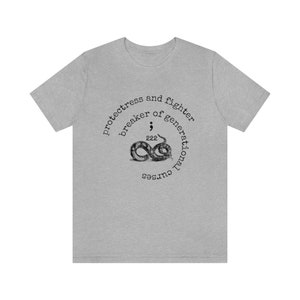 May include: Grey t-shirt with a black and white graphic of a snake with the text "protectress and fighter breaker of generational curses".