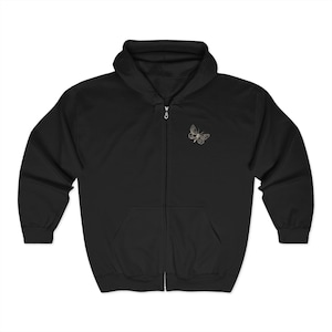 Peut inclure: Sweat à capuche noir avec fermeture éclair et un petit motif de papillon brodé sur la poitrine gauche.