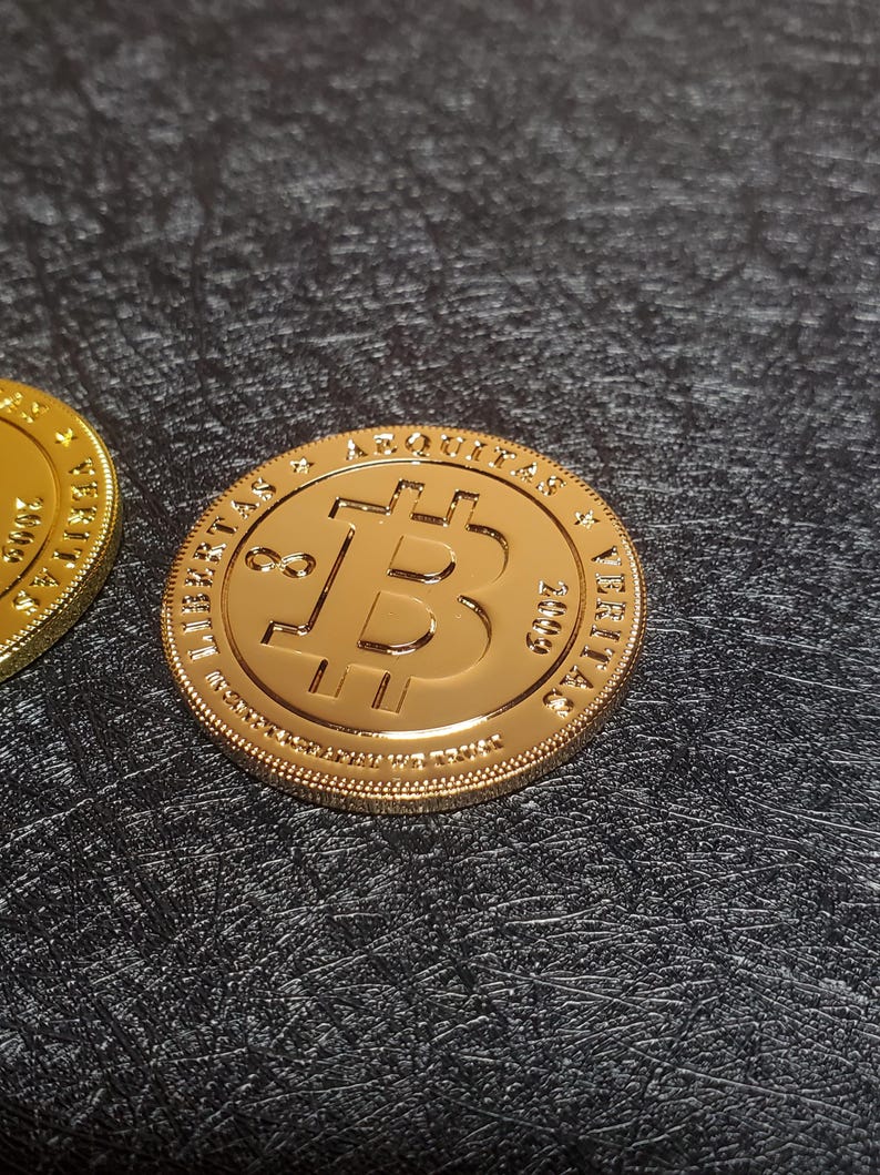 Pu&ograve; includere: Moneta Bitcoin dorata con il testo "LIBERTAS & AQUILA" e "VERITAS" sul bordo.