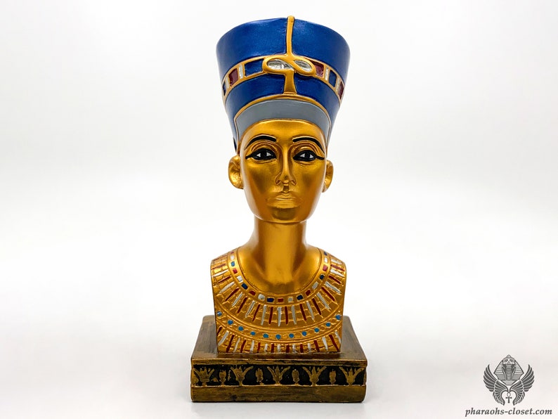 Peut inclure: Buste en or d'une reine &eacute;gyptienne portant une couronne bleue et dor&eacute;e. Le buste est sur une base dor&eacute;e avec des d&eacute;tails complexes.