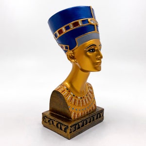 Peut inclure: Buste en sculpture dor&eacute;e d'une reine &eacute;gyptienne portant une coiffe bleue et dor&eacute;e. Le buste est sur une base dor&eacute;e avec des d&eacute;tails complexes.