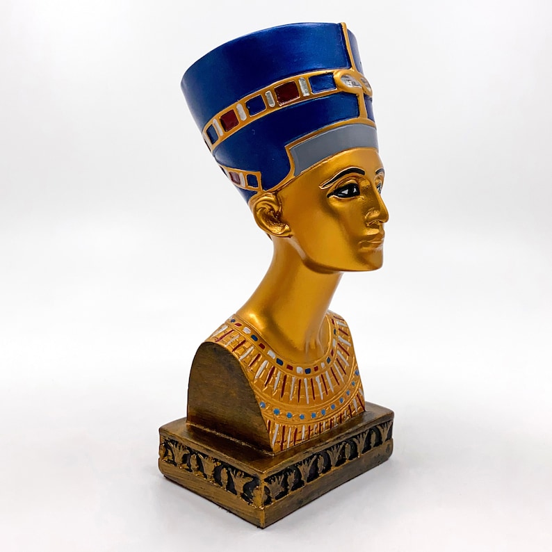 Peut inclure: Buste en sculpture dor&eacute;e d'une reine &eacute;gyptienne portant une coiffe bleue et dor&eacute;e. Le buste est sur une base dor&eacute;e avec des d&eacute;tails complexes.