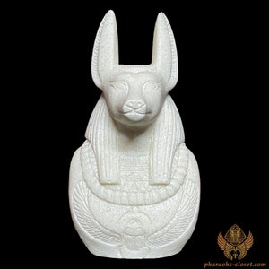 May include: White ceramic bust of the Egyptian goddess Bastet, depicted as a cat with a human head. The bust is detailed with intricate carvings and features a traditional Egyptian collar.