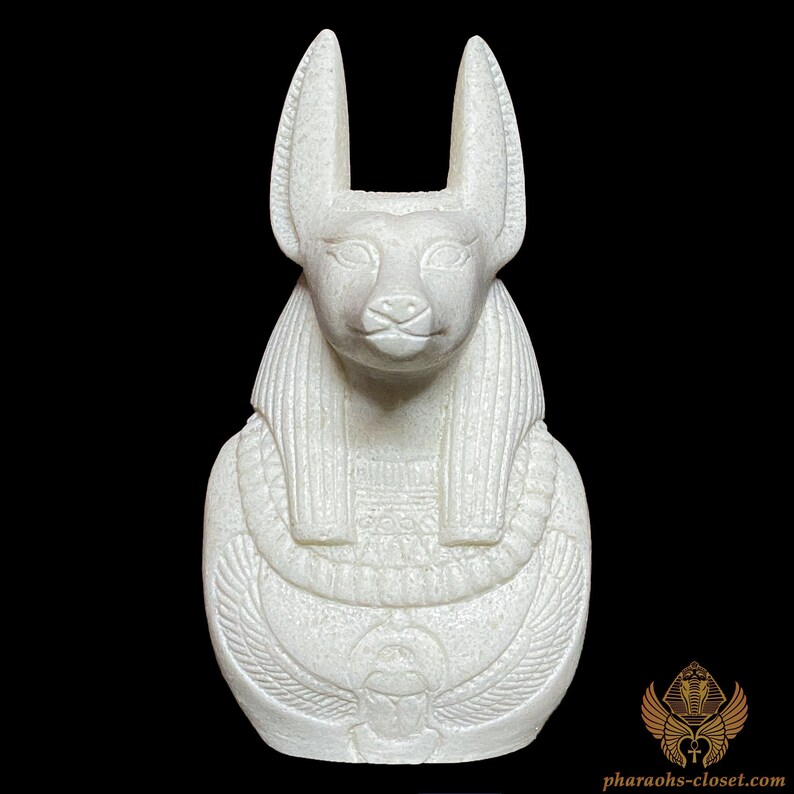 May include: White ceramic bust of the Egyptian goddess Bastet, depicted as a cat with a human head. The bust is detailed with intricate carvings and features a traditional Egyptian collar.