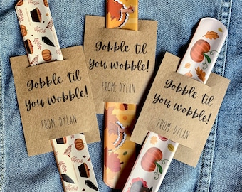 May include: Thanksgiving-themed bookmarks with various designs, including pumpkins, leaves, and turkeys. Each bookmark is paired with a small brown card that reads "Gobble til you wobble!" and "From: Dylan."