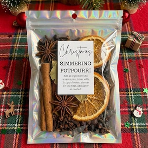 May include: A holographic pouch containing Christmas simmering potpourri with dried orange slices, star anise, cinnamon sticks, cloves, and bay leaves. The label reads: Christmas SIMMERING POTPOURRI. Add all ingredients to a sauce pan, cover with 2 cups of water, simmer on low heat, add water as needed.