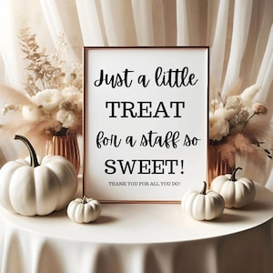 May include: A framed sign with the text "Just a little TREAT for a staff so SWEET! THANK YOU FOR ALL YOU DO!" is surrounded by white pumpkins and floral arrangements. The sign is in a copper-colored frame.