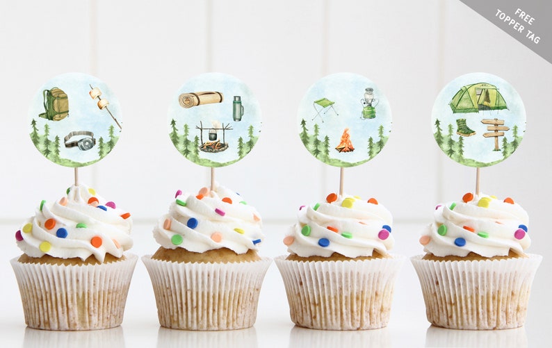 May include: Four cupcakes with white frosting and colorful sprinkles topped with round, illustrated camping-themed cupcake toppers. The toppers feature images of a backpack, a marshmallow on a stick, a sleeping bag, a thermos, a camping chair, a lantern, a campfire, and a tent.