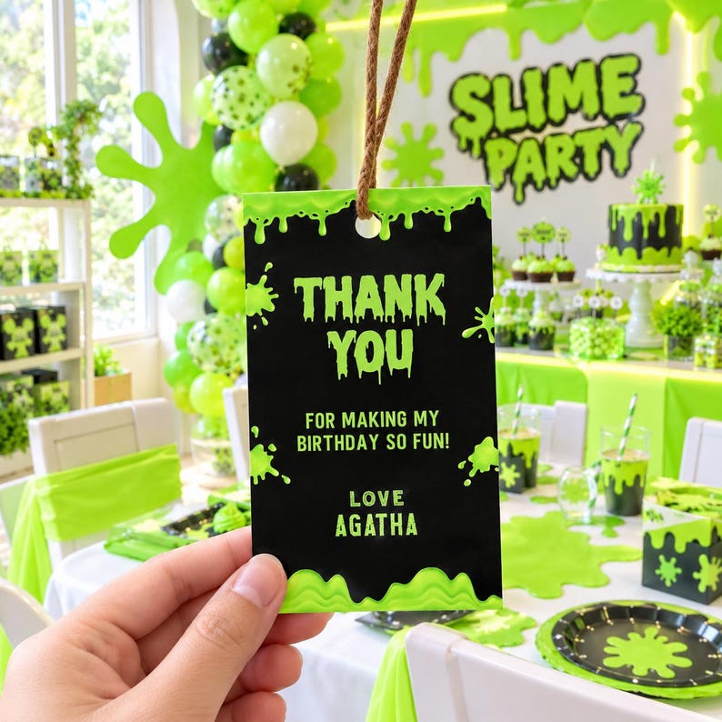 May include: A rectangular black gift tag with a lime green slime drip border and lime green text that reads THANK YOU FOR MAKING MY BIRTHDAY SO FUN! LOVE AGATHA. The tag features a hole at the top with a brown twine string attached for hanging.