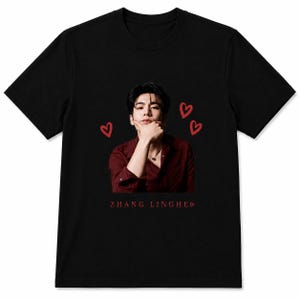 May include: A black short-sleeved t-shirt featuring a central photographic print of a person wearing a dark red button-down shirt with their hand resting on their chin. Three red hand-drawn hearts surround the image, and the text ZHANG LINGHE is printed below in red.