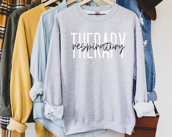 May include: A gray sweatshirt with the text "THERAPY respiratory" printed in black on the front.