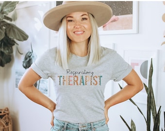 May include: A gray t-shirt with the text "Respiratory Therapist" in colorful letters with a leopard print pattern.
