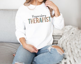 May include: White sweatshirt with the text "Respiratory Therapist" in black letters with a leopard print pattern.