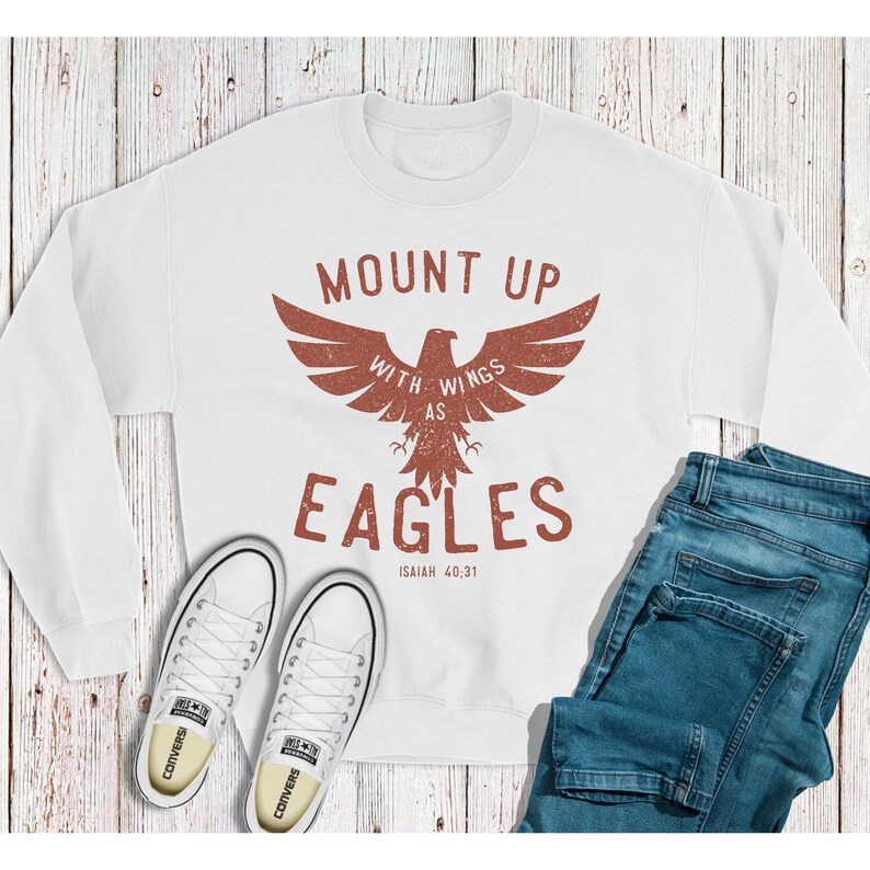 May include: White sweatshirt with a red eagle graphic and the text "Mount Up With Wings As Eagles Isaiah 40:31".