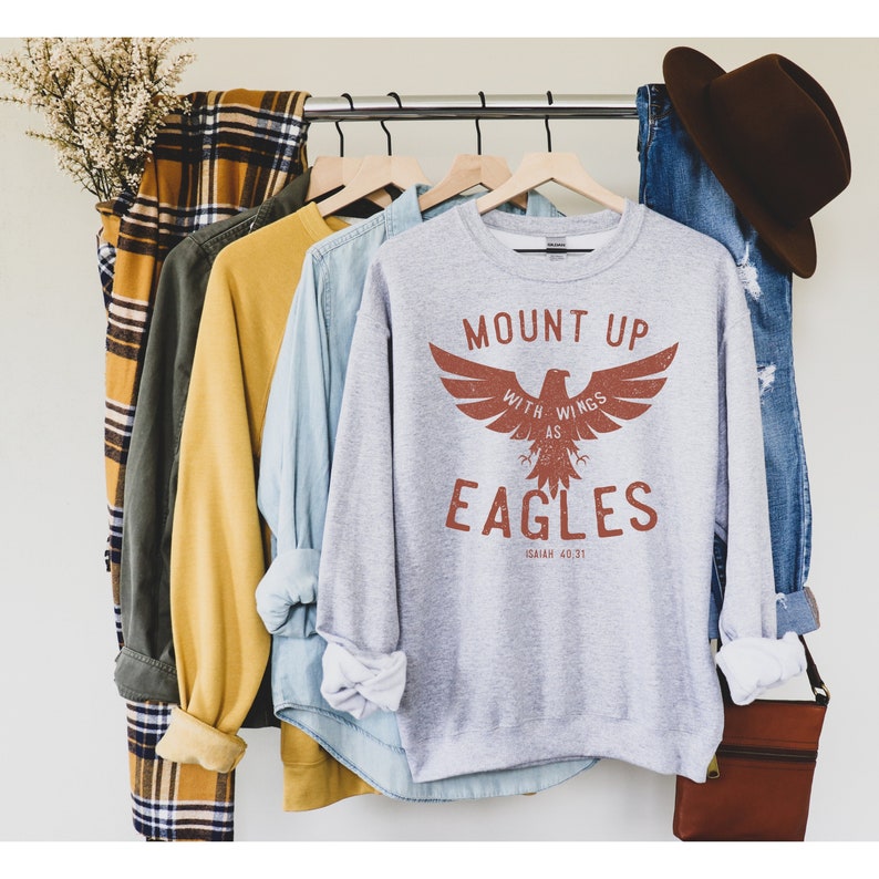 May include: Gray sweatshirt with a brown eagle graphic and the text "Mount Up With Wings As Eagles Isaiah 40:31".