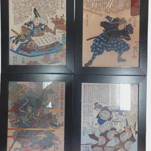 May include: Four framed Japanese woodblock prints. Each print features a different scene with figures in traditional attire, calligraphy, and vibrant colors. The frames are black, and the prints are behind glass.