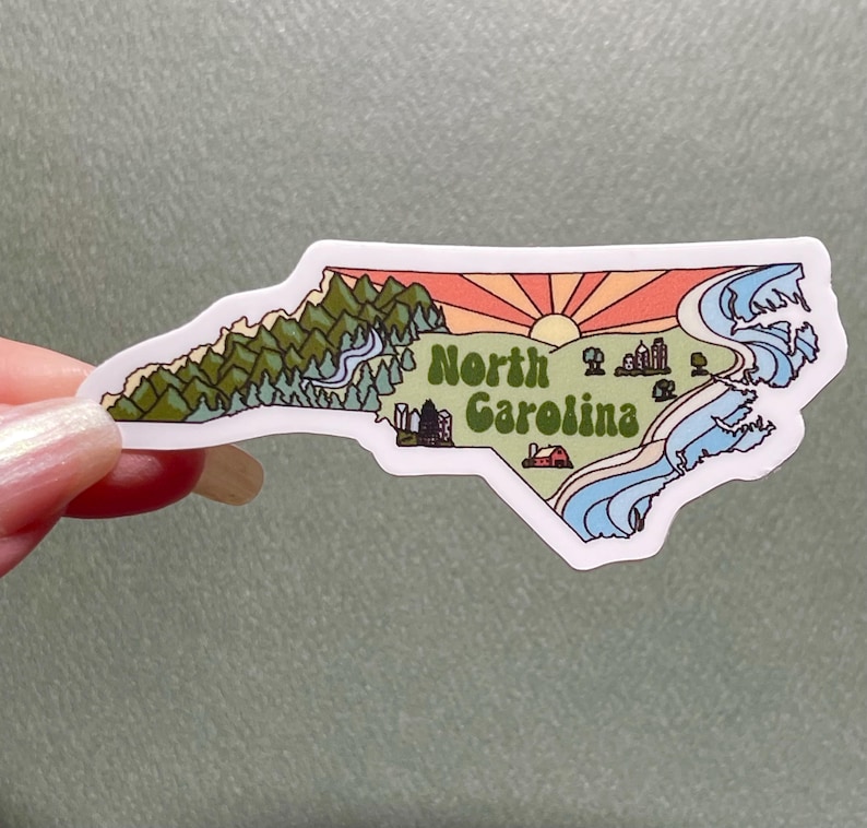 North Carolina sticker featuring Charlotte, Raleigh/Durham area, mountains, beaches, sunshine, and farms. Sticker is in the shape of NC with a white offset.