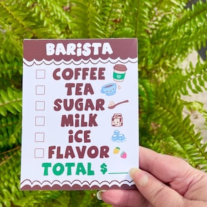 May include: A brown and white checklist with the word "Barista" at the top. The checklist includes items like coffee, tea, sugar, milk, ice, and flavor. There is a line at the bottom for the total price.