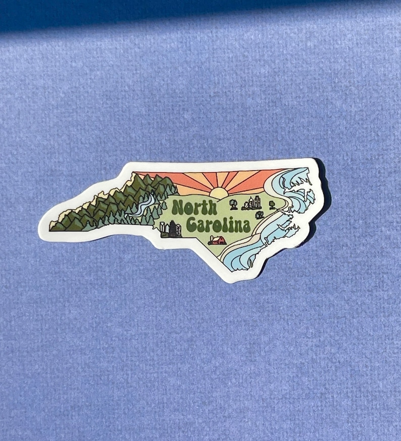 North Carolina sticker featuring Charlotte, Raleigh/Durham area, mountains, beaches, sunshine, and farms. Sticker is in the shape of NC with a white offset.