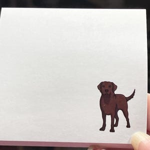 May include: A white sticky note with a brown Labrador Retriever illustration.