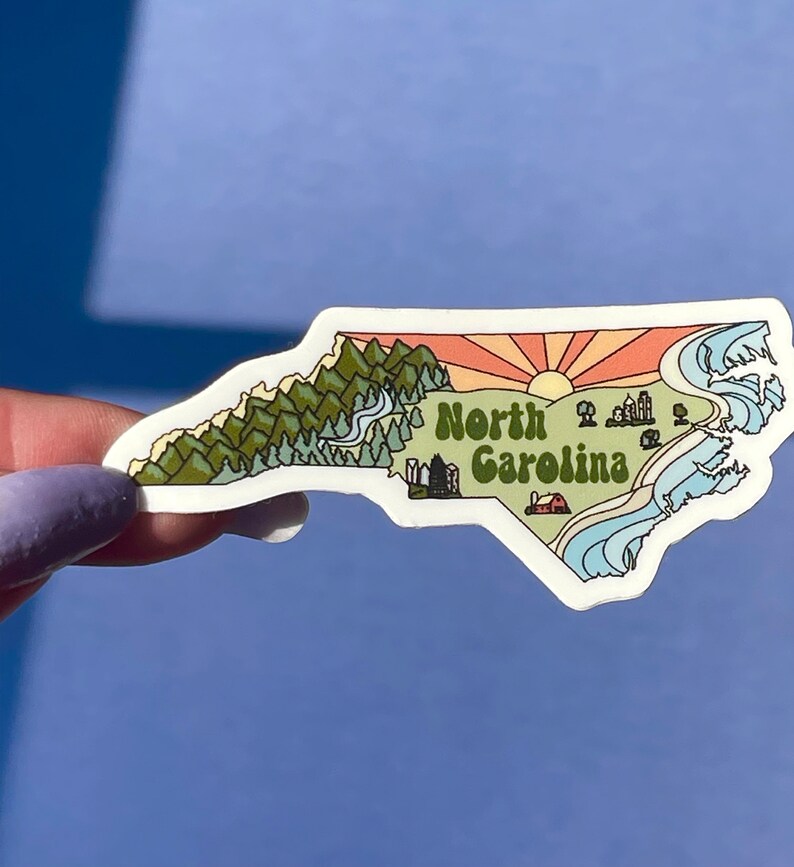 North Carolina sticker featuring Charlotte, Raleigh/Durham area, mountains, beaches, sunshine, and farms. Sticker is in the shape of NC with a white offset.