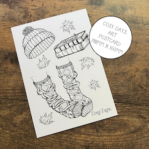 postale de jours douillets | Mini carte postale imprimée sur le thème de l'automne avec une illustration confortable représentant des feuilles qui tombent, un bonnet, des chaussettes et des livres.