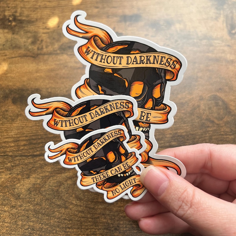 May include: Two black and orange skull stickers with the text "Without darkness there can be no light" and "Without darkness be".
