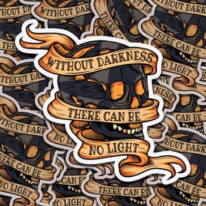 May include: A sticker with a skull and crossbones design. The skull is black and orange, and the crossbones are black. The sticker has the text "Without darkness there can be no light" written on it in a banner style.