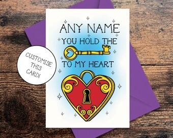 May include: A white card with a purple envelope. The card features a red heart with a gold lock and key. The text on the card reads "ANY NAME YOU HOLD THE KEY TO MY HEART".