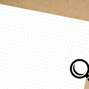 May include: A white sheet of paper with a black magnifying glass in the bottom right corner. The paper has a pattern of small black dots.