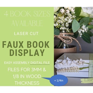 May include: Laser cut faux book display with four different sizes available. The display is made of white wood and features a green and white gingham ribbon. The display is shown with a white flower arrangement in a glass jar.