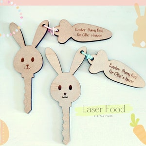 May include: Two wooden bunny keychains with carrot-shaped tags that read "Easter Bunny Key for Ollie's house". The keychains are laser cut and have a light brown color.