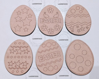 May include: Six unfinished wooden Easter egg shapes with various designs, including stars, flowers, bunnies, and wavy lines. The words "EASTER" are written on two of the eggs.