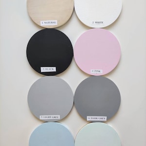 May include: Eight round wooden discs painted in different colors: natural wood, white, black, pink, light gray, dark gray, baby blue, and light mint. Each disc has a number and color name printed below it.