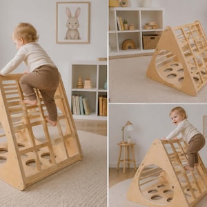 Op de afbeelding: Een houten klimdriehoek met een ladder en cirkelvormige uitsparingen. Een kind klimt op de structuur. Het frame is van lichtgekleurd hout en het ontwerp is eenvoudig en modern. Het speelgoed is ontworpen voor binnenspelen.