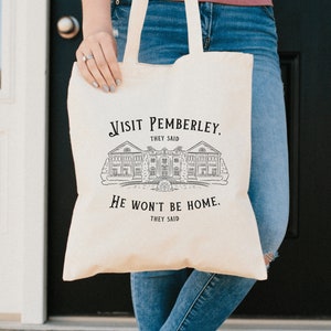 May include: A white canvas tote bag with black text that reads "Visit Pemberley. They said. He won't be home. They said." The bag features a black and white illustration of a house.