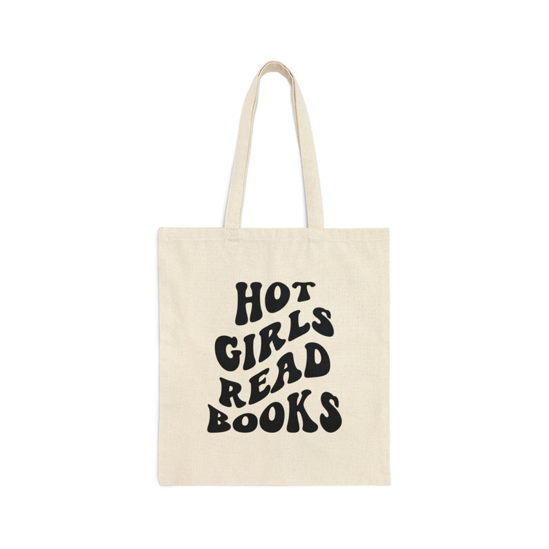 K&ouml;nnte beinhalten: Eine beige Tragetasche mit schwarzem Text, der in einer Retro-Schrift "HOT GIRLS READ BOOKS" lautet.