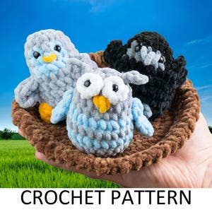 May include: A crochet pattern for three amigurumi birds: a blue and gray owl, a gray bird, and a black bird. The birds are sitting in a brown crocheted nest.