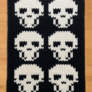 Vingerbreipatroon met doodskopmotief. Grof gebreide dekenpatroon voor Halloween. Grof gebreide dekenpatroon.