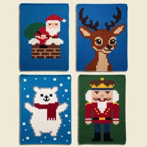 May include: Four rectangular knitted panels featuring holiday designs. One shows Santa in a chimney, one a reindeer, one a polar bear in a red scarf, and one a nutcracker. The panels are blue and green with detailed multi-colored yarn patterns.