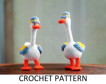 May include: Two crocheted goose toys with blue and yellow accents. The geese are wearing blue and yellow hats. The geese are standing on a wooden surface.