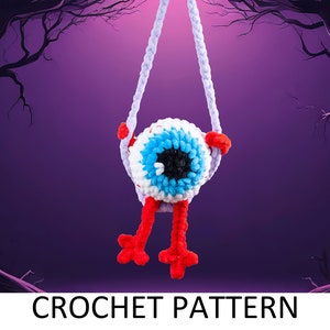 May include: A crocheted eyeball hanging from a purple rope swing. The eyeball is blue, white, and black with red arms and legs. The background is a dark purple with trees on either side.